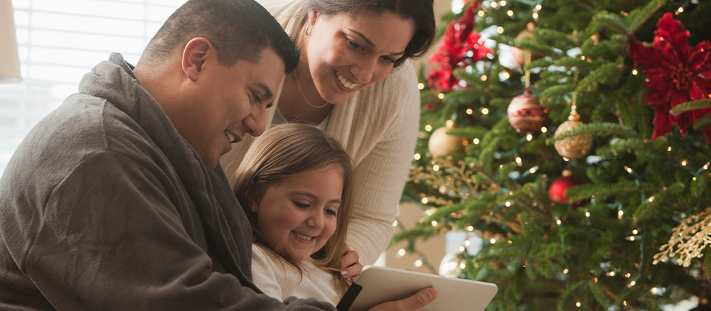 Family watching tablet near a christmas tree
