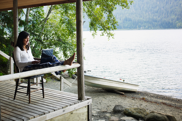 Woman on laptop by the lake